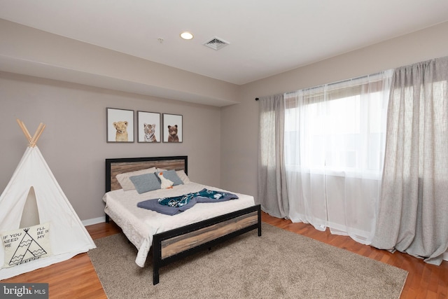 bedroom with recessed lighting, visible vents, and wood finished floors
