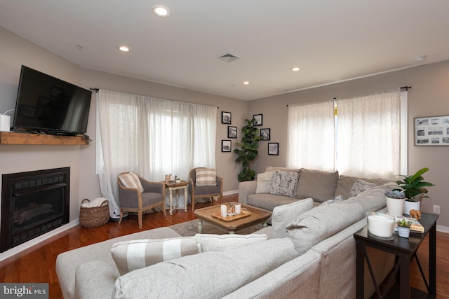 living room with a healthy amount of sunlight, visible vents, and wood finished floors