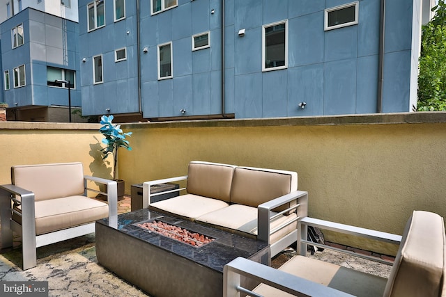 view of patio with an outdoor living space with a fire pit