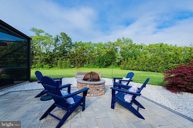 view of patio featuring a fire pit and glass enclosure