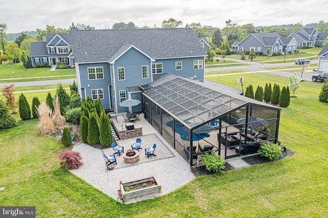 rear view of property with a lawn, a patio, a fire pit, and an outdoor pool