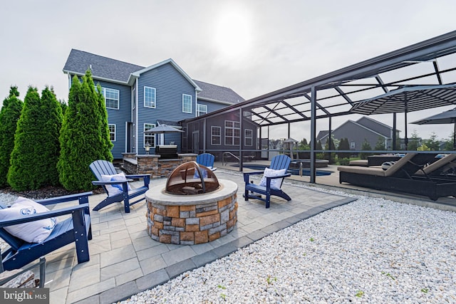view of patio featuring an outdoor fire pit and a lanai