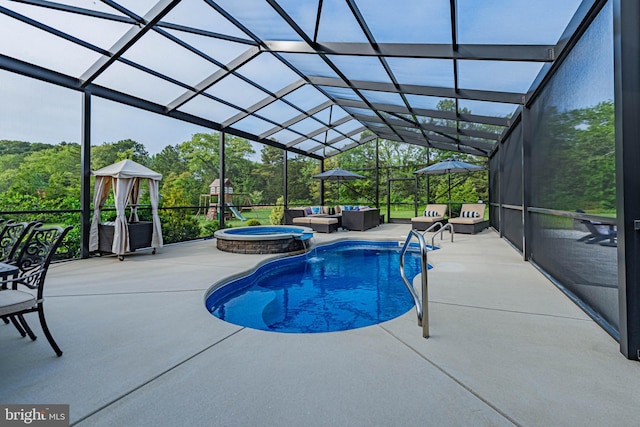 view of swimming pool featuring a pool with connected hot tub, a patio, an outdoor living space, and glass enclosure