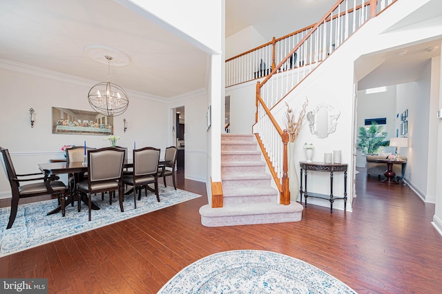 interior space featuring an inviting chandelier, wood finished floors, crown molding, stairway, and baseboards