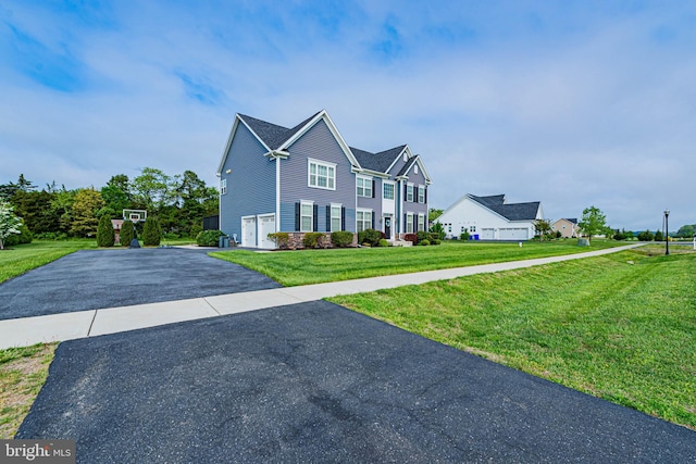 view of front facade with a front yard, aphalt driveway, and a garage