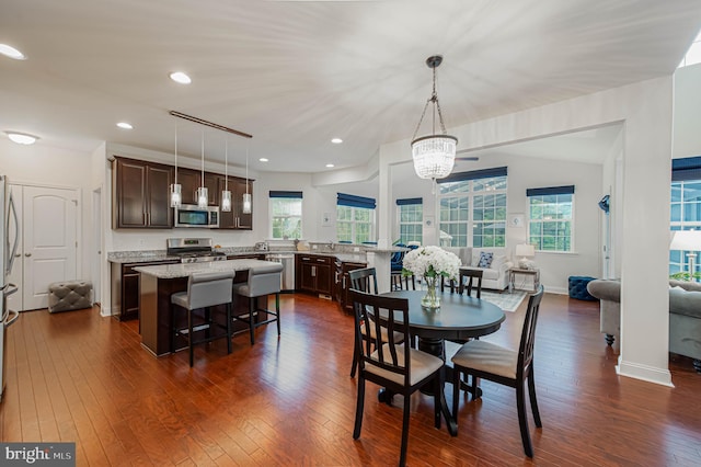 dining space featuring a wealth of natural light, an inviting chandelier, recessed lighting, and dark wood-type flooring
