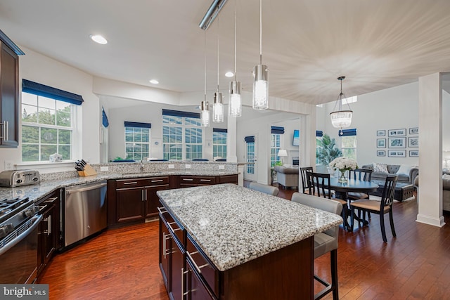 kitchen featuring open floor plan, a breakfast bar area, stainless steel dishwasher, and black range with gas stovetop