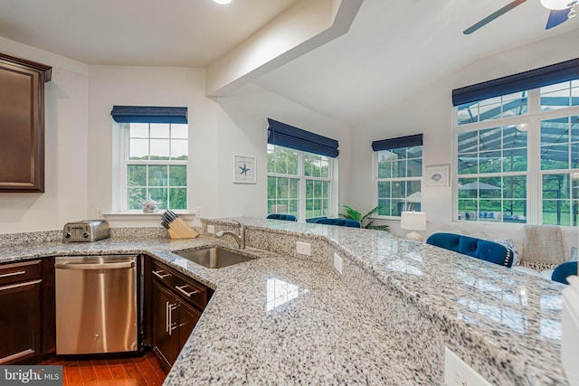kitchen with stainless steel dishwasher, dark brown cabinets, ceiling fan, a sink, and wood finished floors