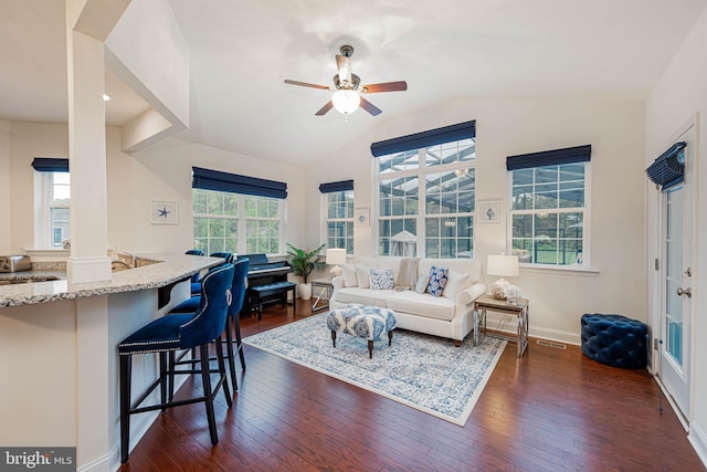 living room with visible vents, baseboards, dark wood-style flooring, ceiling fan, and vaulted ceiling
