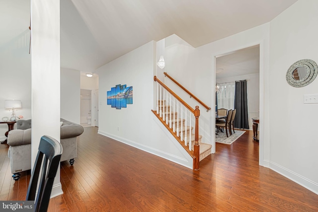 interior space with a chandelier, stairs, baseboards, and hardwood / wood-style floors