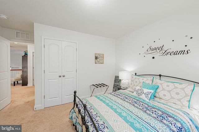 bedroom featuring baseboards, light carpet, a closet, and visible vents