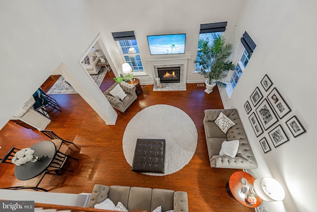 living room with plenty of natural light, a fireplace, baseboards, and wood finished floors