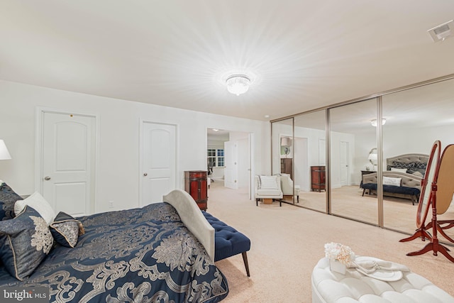 bedroom with a closet, visible vents, and carpet