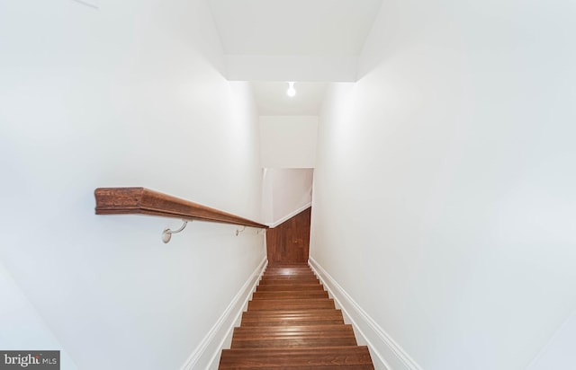 stairway featuring baseboards and wood finished floors