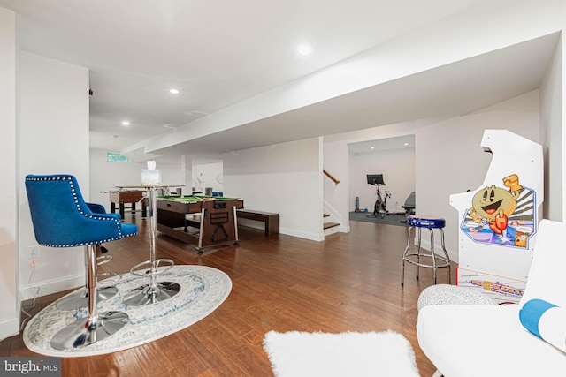 living area featuring recessed lighting, wood finished floors, baseboards, and stairs