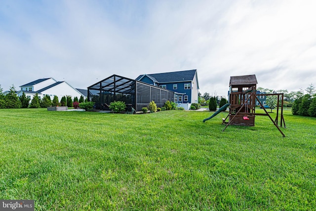 view of yard with a playground and glass enclosure