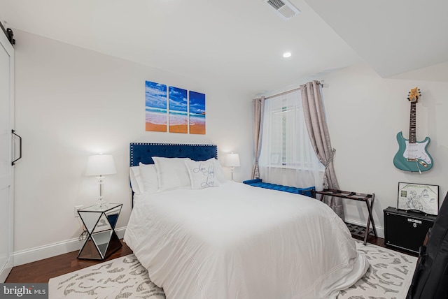 bedroom with wood finished floors, visible vents, baseboards, and recessed lighting