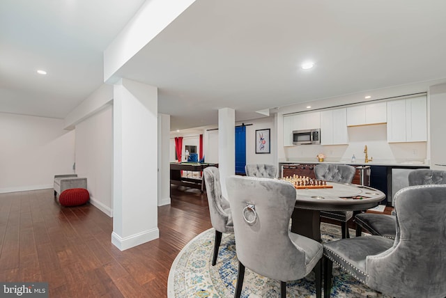 dining room with wet bar, dark wood-style flooring, baseboards, and recessed lighting