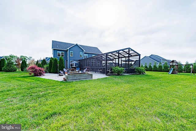 view of yard with a playground, a patio, and glass enclosure