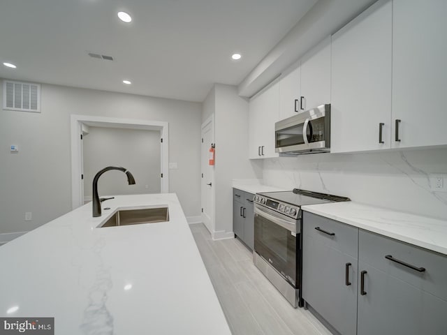 kitchen featuring a sink, appliances with stainless steel finishes, recessed lighting, and visible vents