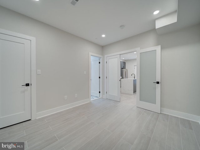 unfurnished bedroom featuring recessed lighting, baseboards, and light wood-type flooring