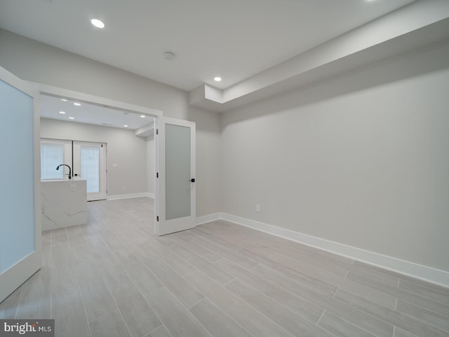 unfurnished room with recessed lighting, light wood-style flooring, baseboards, and french doors