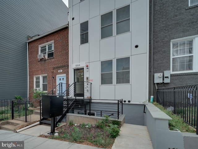 view of front facade with brick siding and fence