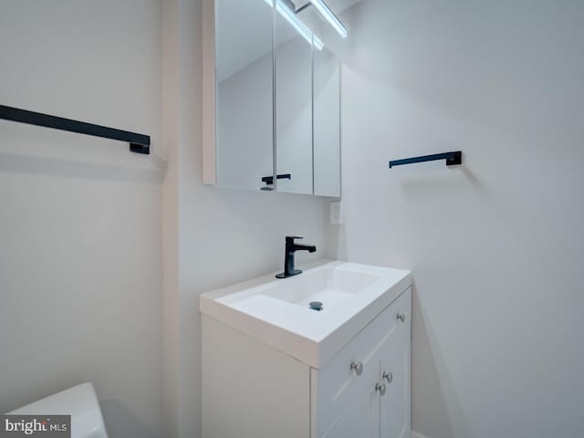 half bathroom featuring vanity and toilet
