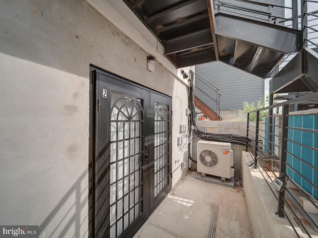 view of exterior entry featuring french doors, ac unit, and stucco siding