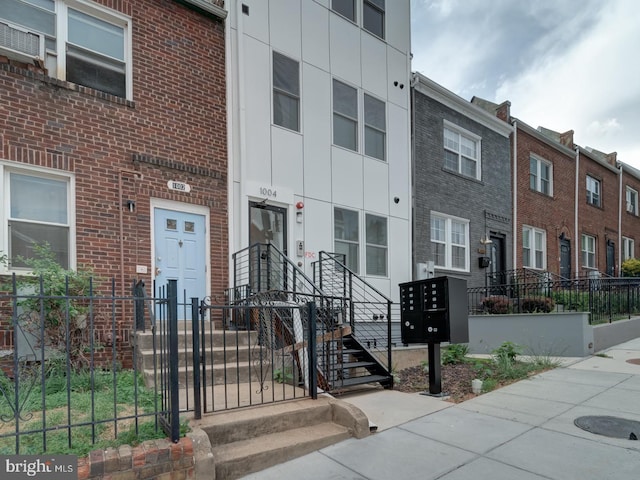 view of property with brick siding and fence
