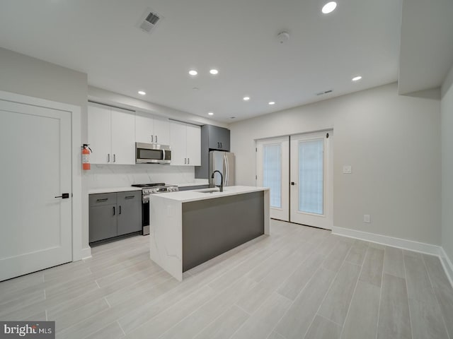 kitchen with a sink, light countertops, stainless steel appliances, recessed lighting, and visible vents