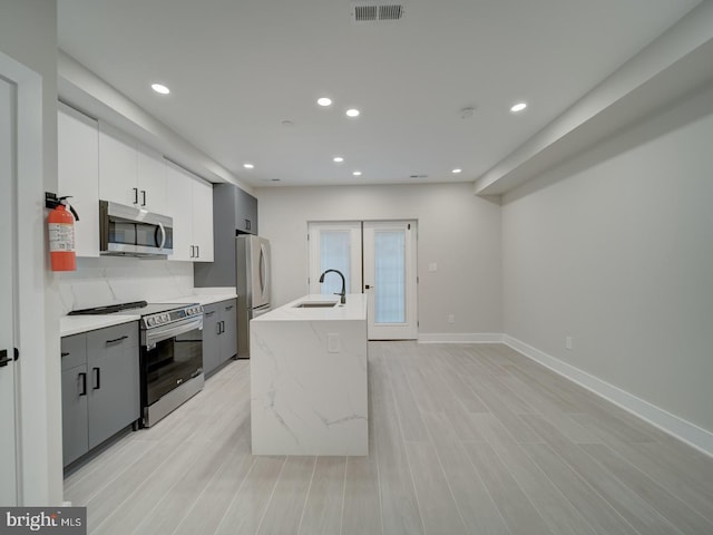kitchen with light countertops, stainless steel appliances, recessed lighting, and a sink