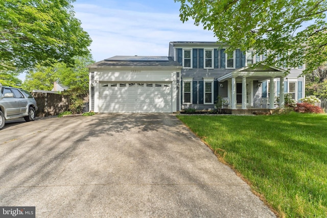 view of front of house featuring driveway, an attached garage, a porch, and a front lawn