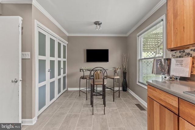 dining space featuring crown molding, visible vents, and baseboards