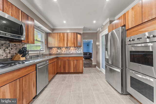 kitchen with tasteful backsplash, crown molding, a sink, appliances with stainless steel finishes, and visible vents