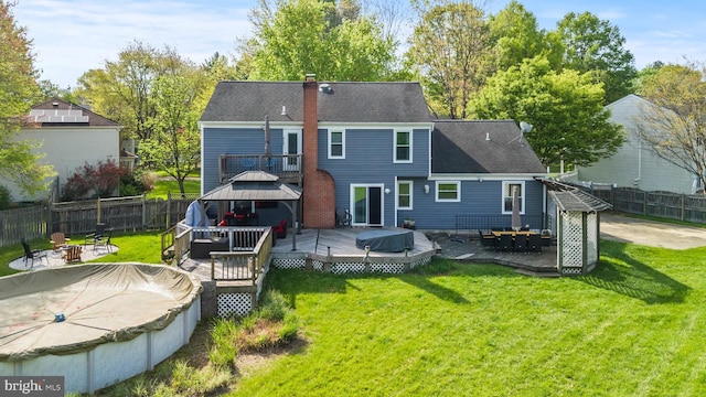 back of house featuring a fire pit, a gazebo, a wooden deck, and a fenced backyard