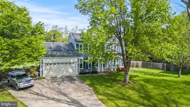 view of front of house featuring fence, a garage, solar panels, a front lawn, and concrete driveway