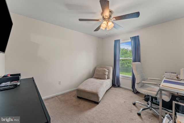 carpeted office space with ceiling fan and baseboards