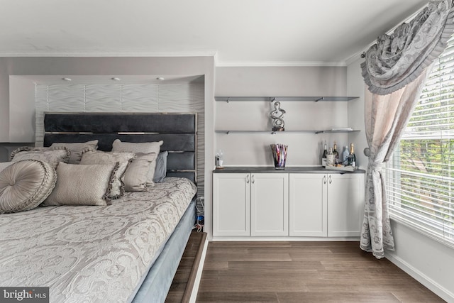 bedroom with wood finished floors, bar, crown molding, and baseboards