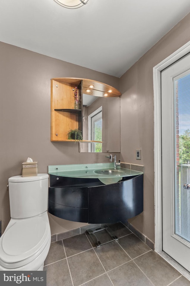 bathroom featuring vanity, toilet, tile patterned flooring, and baseboards