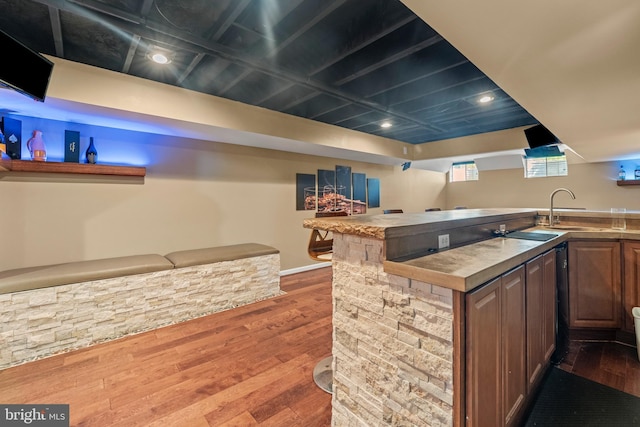 kitchen featuring wood finished floors, baseboards, and a sink