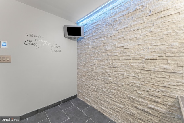 interior space featuring dark tile patterned floors and baseboards