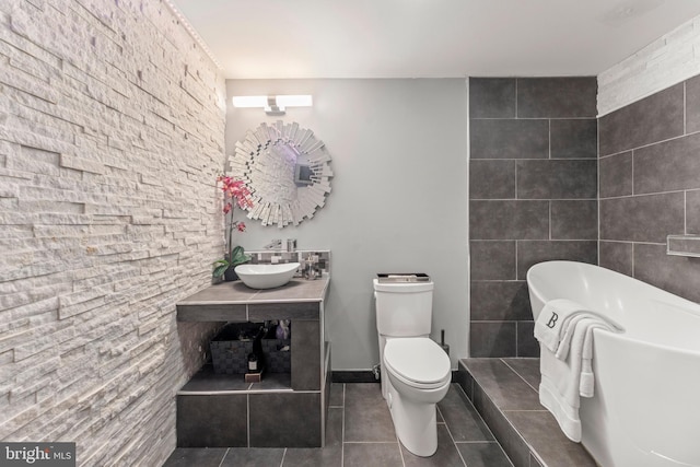 bathroom with a soaking tub, toilet, tile patterned flooring, and vanity