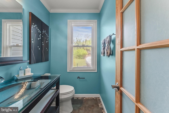 bathroom with toilet, ornamental molding, vanity, and baseboards