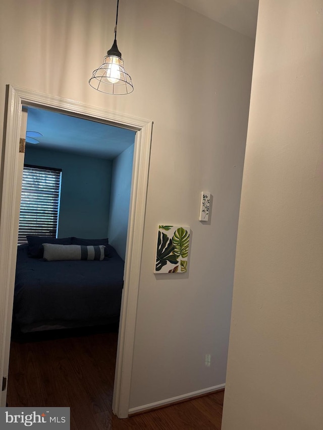 corridor featuring wood finished floors and baseboards