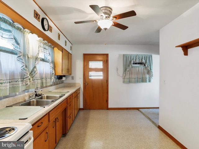 kitchen featuring a sink, light countertops, baseboards, and brown cabinetry