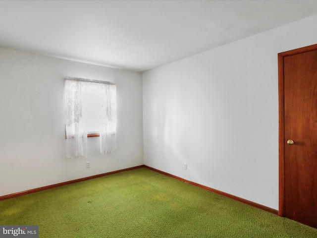 carpeted empty room with baseboards