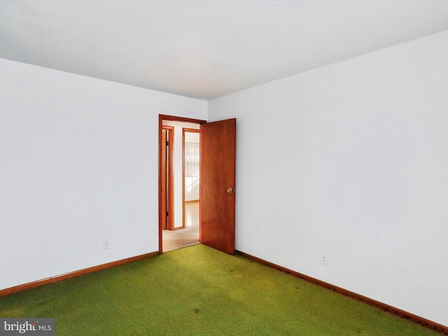 carpeted spare room with baseboards