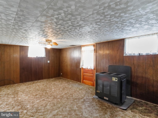 interior space featuring plenty of natural light, carpet flooring, and wood walls