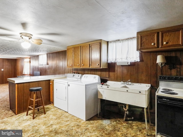 laundry room featuring ceiling fan, laundry area, wood walls, and washing machine and clothes dryer